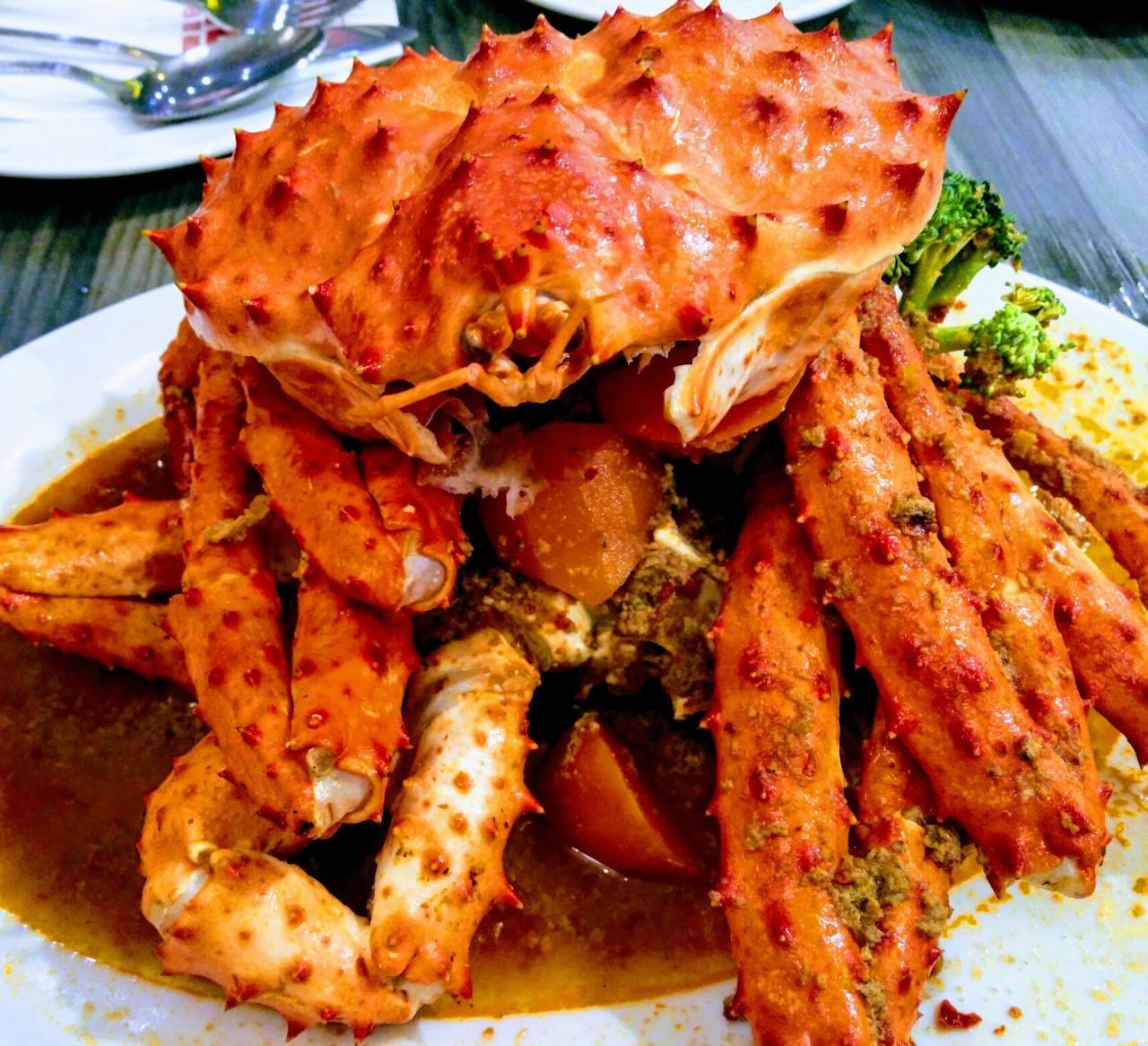 Mouth-watering crab dish garnished with broccoli, perfect for seafood lovers.